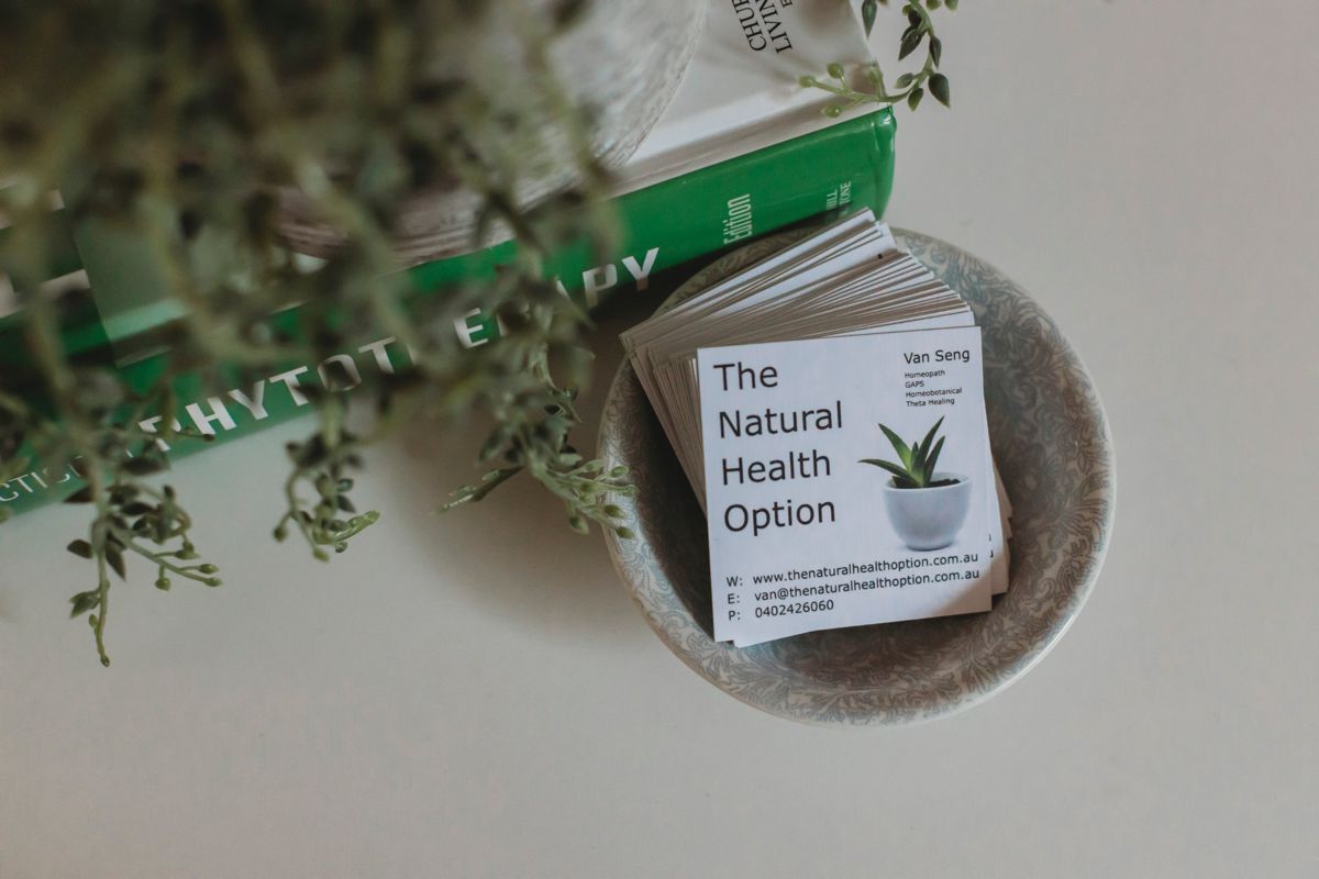 Business cards in a patterned bowl beside a phytotherapy text
