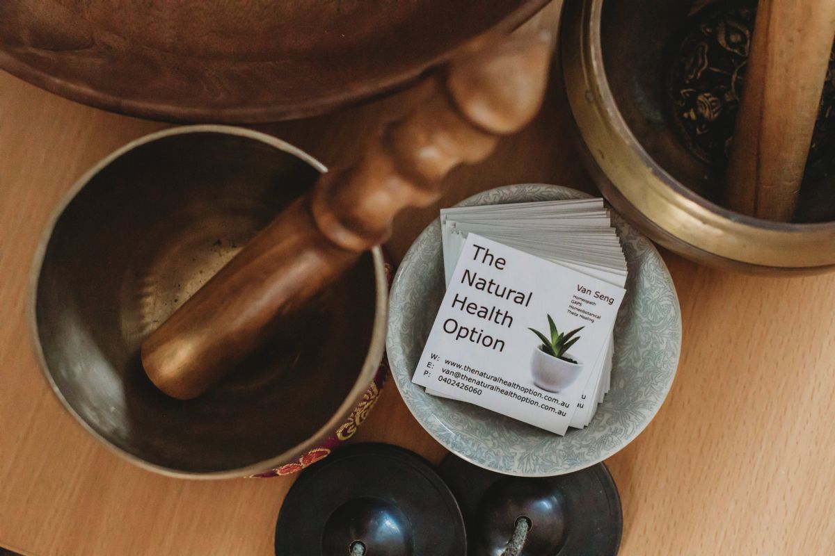 Singing bowls beside a Natural Health Option card